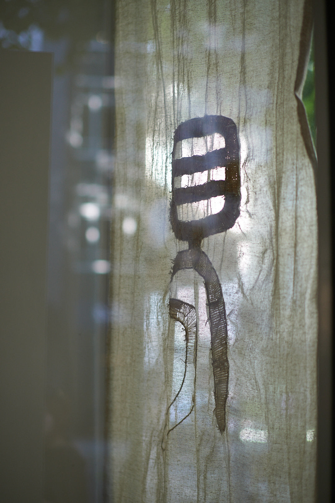 Textile-based artwork by Lu Lei from the exhibition 'Be the Crossroads', featuring layered, semi-transparent fabric with stitched black abstract forms.
